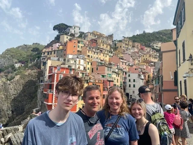 A group of people standing in front of a hillside.