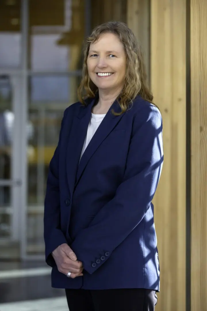 A woman in a blue suit standing outside.