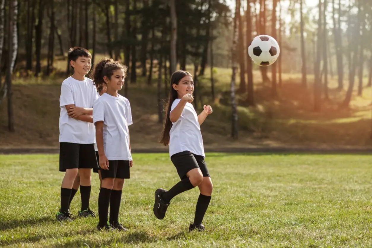 A group of young people playing soccer on the grass.