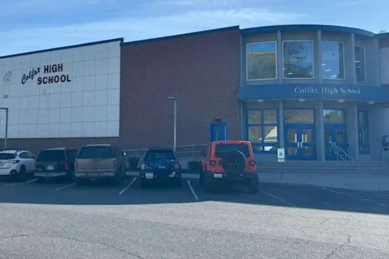 A parking lot with cars parked in front of a building.